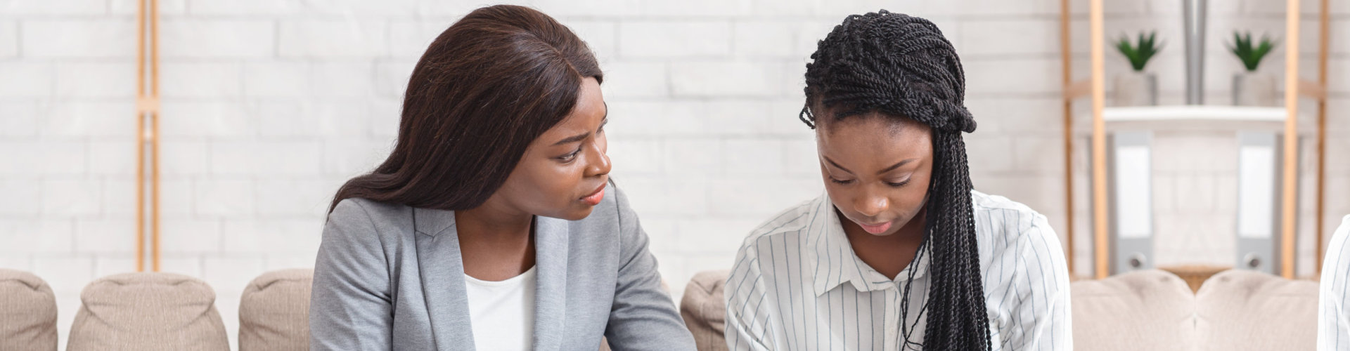 psychologist comforting depressed female patient during therapy session